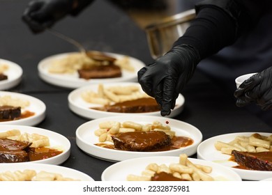 chef is serving pasticada with gnocchi, beef stew in a sauce. Croatian cuisine