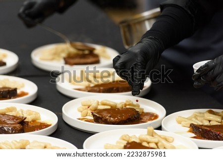 chef is serving pasticada with gnocchi, beef stew in a sauce. Croatian cuisine