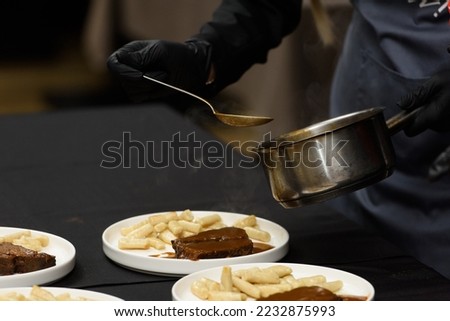 chef is serving pasticada with gnocchi, beef stew in a sauce. Croatian cuisine