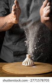 Chef shaping khinkali dumpling while flour falls from hands creating dynamic motion on wooden board in kitchen