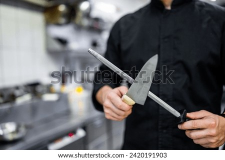 Chef sharpening a kitchen knife with Honing steel
