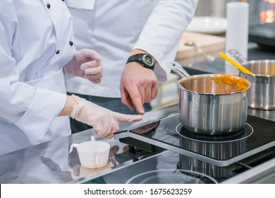 Chef shows how to use electric stove at cuisine of restaurant. Professional cooking, training, education, learning, instruction, catering, cookery, gastronomy and food concept - Shutterstock ID 1675623259