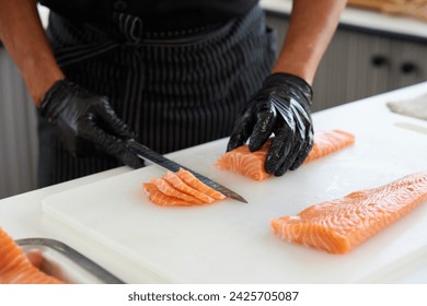 Chef slicing a big salmon meat in the kitchen - Powered by Shutterstock