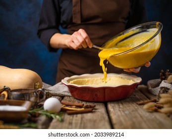 The Chef Spreads The Pumpkin Filling Onto The Dough In A Baking Dish. The Process Of Making American Pumpkin Pie. Thanksgiving, Halloween, Christmas, New Years.