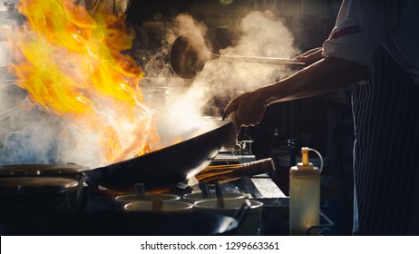 Chef Stir Fry In Wok. Dramatic Cooking With Fire Hard