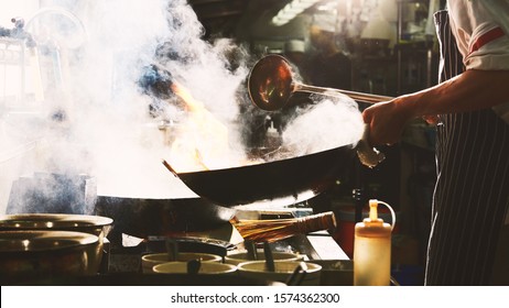 Chef Stir Fry In Wok. Dramatic Cooking With Fire Hard
