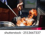 Chef Stir-Frying Seafood and Vegetables in a Wok at a Street Food Festival.