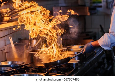 Chef Is Stirring Vegetables In Wok On Open Fire.