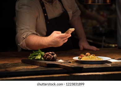 Chef taking pictures of pasta in restaurant kitchen - Shutterstock ID 1223831899