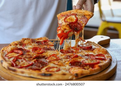 The chef is taking a slice of freshly baked pizza, close-up - Powered by Shutterstock