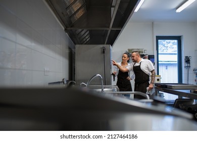 Chef teaching cook how to use combi oven indoors in restaurant kitchen. - Powered by Shutterstock
