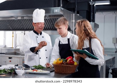 Chef teaching students how to cook in the kitchen. - Powered by Shutterstock