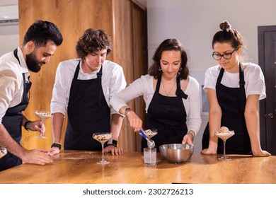 Chef teaching trainees how to make ice cream. Cooking tasty ice cream dessert made from chocolate and vanilla in glass bowl
