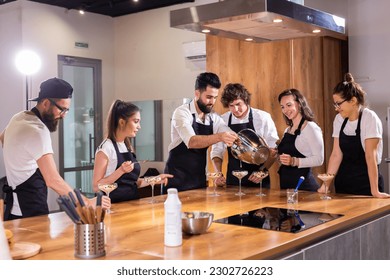 Chef teaching trainees how to make ice cream. Cooking tasty ice cream dessert made from chocolate and vanilla in glass bowl