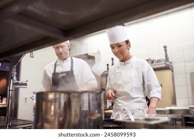 Chef, teamwork and cooking in professional kitchen at stove top or fine dining cuisine, hospitality or service. Man, woman an hat as restaurant career or food preparation or dinner rush, meal or help - Powered by Shutterstock