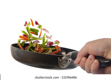 Chef Is Tossing Veggies Into A Pan With White Background