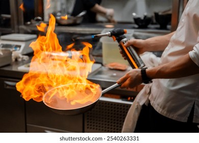 A chef uses a blowtorch to create dramatic flames in a modern kitchen. The intense fire illuminates the scene, showcasing advanced culinary techniques and the chef’s skill - Powered by Shutterstock