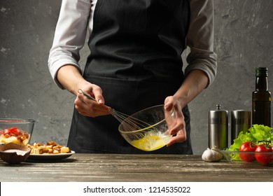 The chef whips the sauce vegetarian salad with seafood. The background of the concrete wall with the text area for the design of the restaurant menu - Shutterstock ID 1214535022
