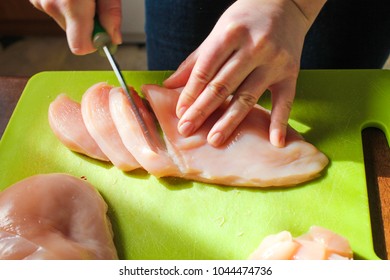 Chef Woman Cuts Chicken At The Kitchen