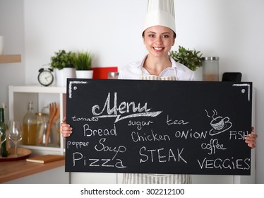 Chef woman holding the menu board , standing in kitchen - Powered by Shutterstock