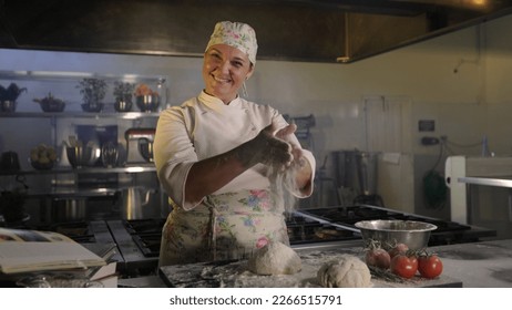 Chef woman preparing dough. Handling wheat flour. Background industrial kitchen.  - Powered by Shutterstock