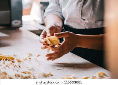 Chef Woman's Hands Making Tagliatelle Pasta. Cooking Process. Raw Food Photography Concept.