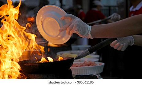 Chef at work - Flambe Cooking. Food Flaming In Pan. Commercial kitchen.
Professional chef in a commercial kitchen cooking flambe style. Chef Flambe Cooking. 