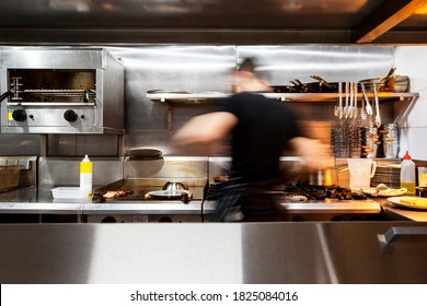 Chef Working In Small Restaurant Kitchen.