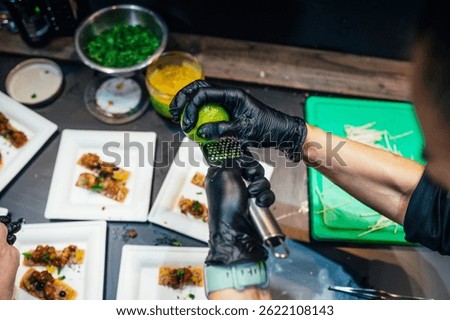 Chef zesting lime over dish