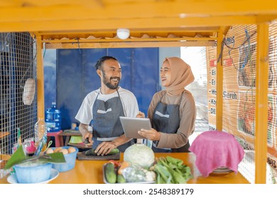 Chefs collaborating happily at a colorful food stall preparing fresh ingredients. - Powered by Shutterstock