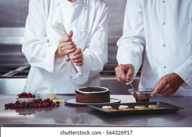 Chefs decorating a cake in a restaurant - Powered by Shutterstock