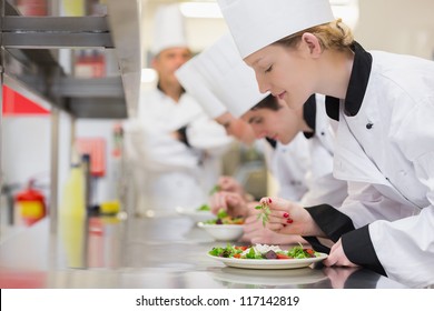 Chef's Finishing Their Salads In Culinary Class In Kitchen