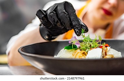 Chef's hand in gloves cooking crepe pancake on plate in kitchen - Powered by Shutterstock