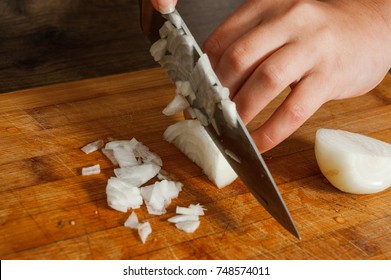 Chefs hands chopping onion on wooden board - Powered by Shutterstock