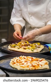 Chefs Hands In Gloves And Preparing  Making Pizza At Kitchen.