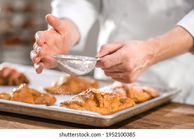 Chefs hands with small sieve over baking - Powered by Shutterstock