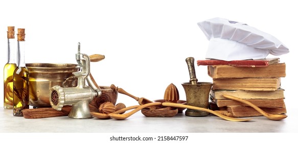 Chef's Hat, Vintage Cookbooks, And Old Kitchen Utensils Isolated On A White Background.