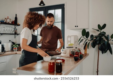 Chefs preparing ingredients for meal in modern kitchen, adding spices and flavors to create delicious dish, demonstrating teamwork and culinary skills - Powered by Shutterstock