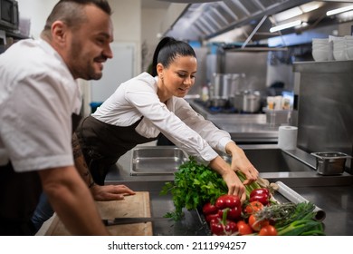 Chefs preparing vegetables for cutting in commercial kitchen. - Powered by Shutterstock