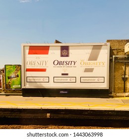 Chelmsford, UK - 5 July 2019: Obesity Causes Cancer Too. Cigarette Style Health Warning On A Billboard At The Train Station.