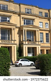 Cheltenham Gloucestershire UK April 22nd 2021 Working From Home - A Woman In Red Sits At An Open Window On A Sunny Balcony Working At A Computer In Her Georgian Regency Town House 