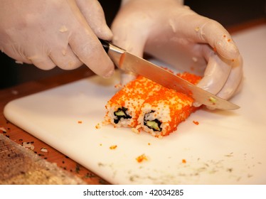 CHELYABINSK ? NOVEMBER 17: Sushi master class, Holiday Inn Chelyabinsk-Riverside 4*. Gloved hands cutting rolls with knife