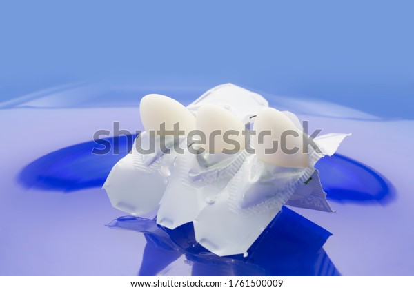 Chemical barrier contraceptive method. Three\
sperm-killing suppositories in half-peeled suppository shells on\
blue background