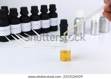 chemical beaker , flask is on white table with blotting paper , fragrance bottle and essential oil bottle are used to blend the nice scent for making perfume and candle by perfumer in the laboratory Сток-фото © 
