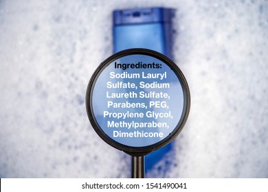 Chemical Components On The Shampoo Label:  Sodium Lauryl Sulfate (sls, Sles). A Hand Holds A Blue Jar And A Magnifier, Where The Harmful Ingredients Of A Detergent Are Written In Close Up.