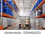 Chemical factory warehouse. Hangar interior with barrels on racks. Industrial building for storing chemicals. IBC container between warehouse shelves. Storage with chemical liquids in tanks. 