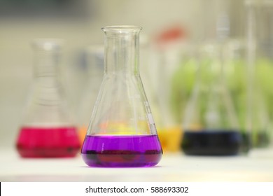 Chemical flask with a blue laboratory test tubes inside,