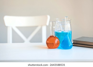 Chemical flasks with colored vibrant reagents stand on a wooden table in a school. Scientific tests and experiments in a chemistry lesson. Nobody.	