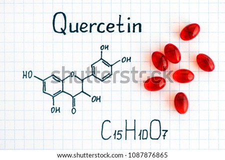 Chemical formula of Quercetin with red pills. Close-up.