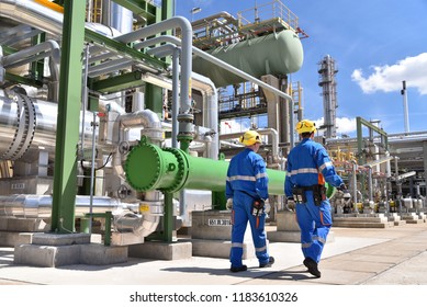 chemical industry plant - workers in work clothes in a refinery with pipes and machinery  - Shutterstock ID 1183610326